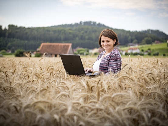 Bäuerin mit Laptop im Feld © Wirlphoto