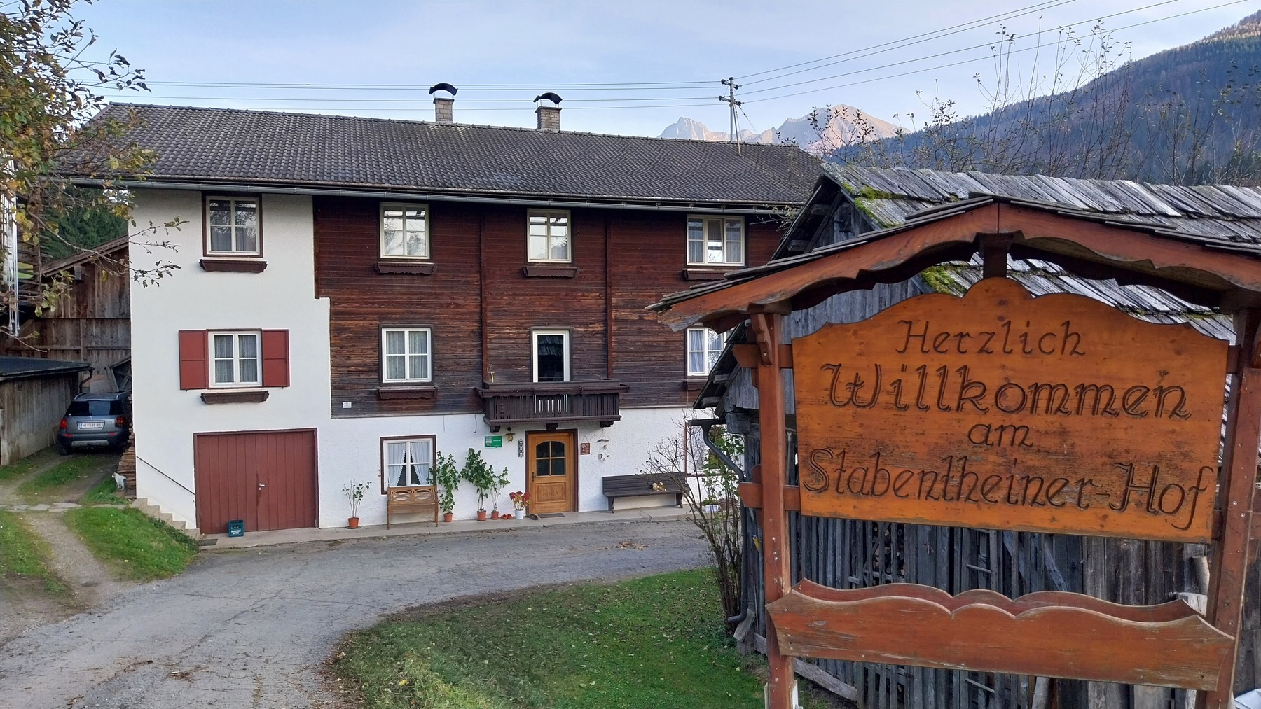 Man sieht das Hofgebäude und das Hofschild mit dem Namen darauf.