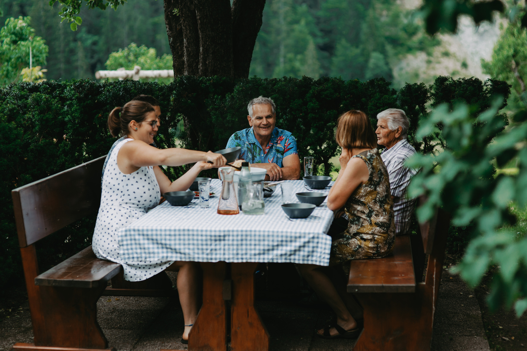 Vier Personen sitzen an einem Tisch mit Essen und Trinken