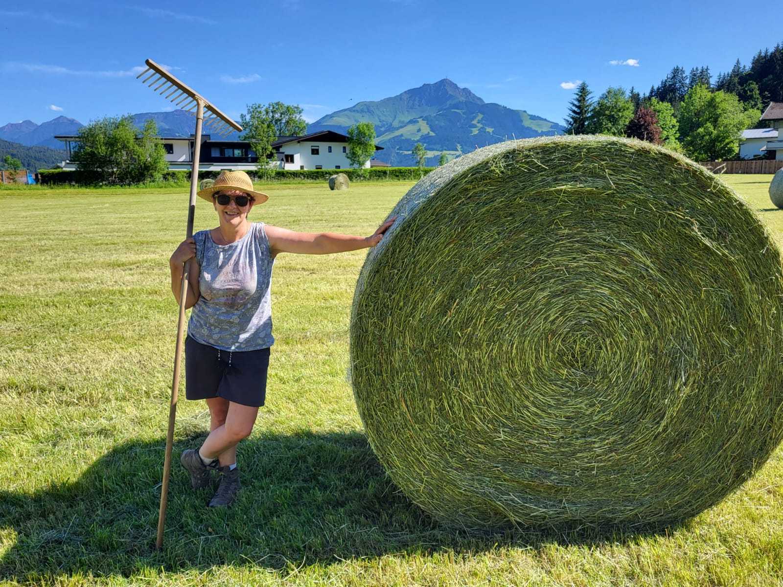 Eine Frau steht neben einem Heuballen