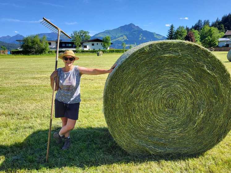 Eine Frau steht neben einem Heuballen