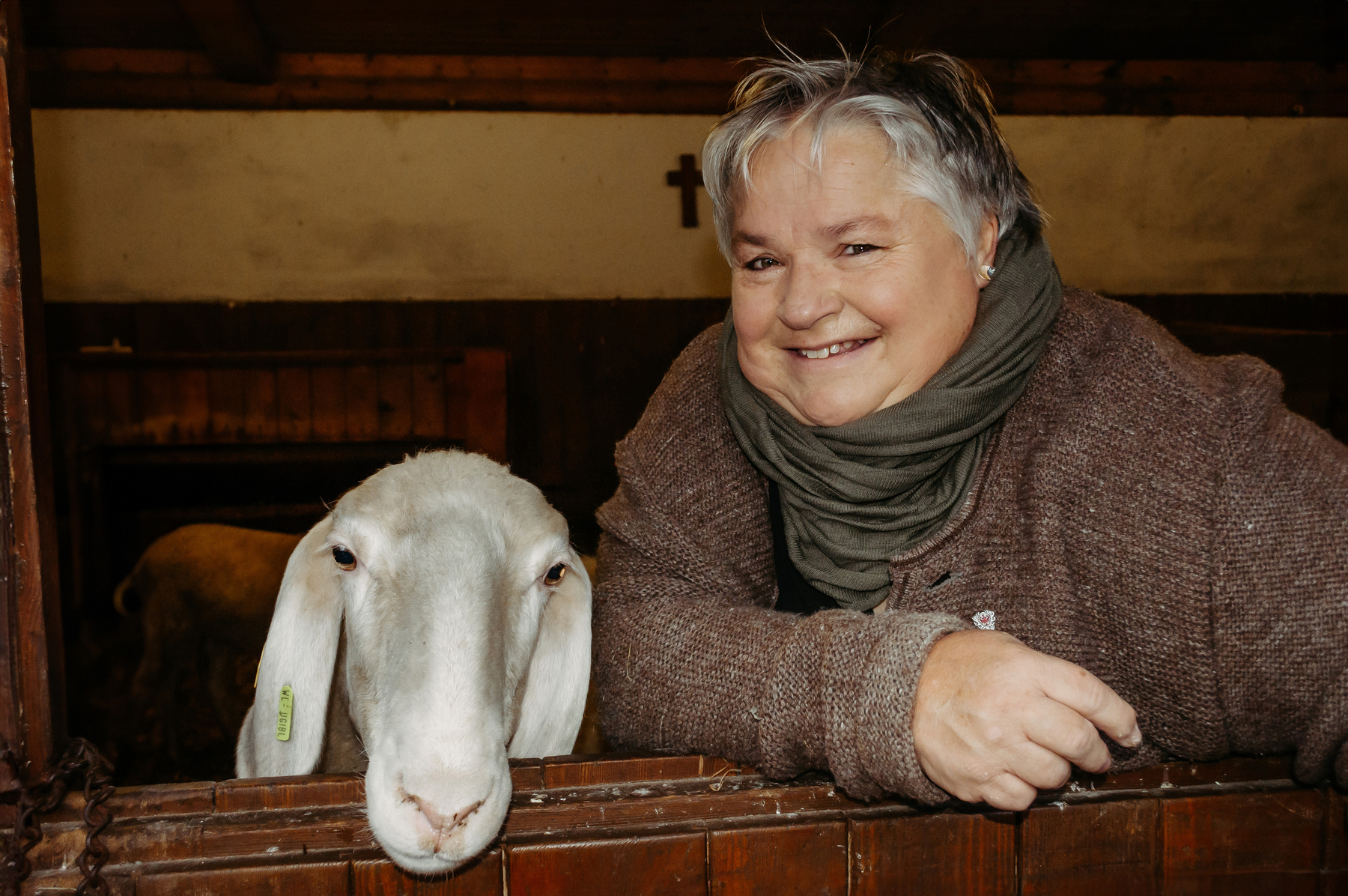 Frau und Schaf lächeln in die Kamera