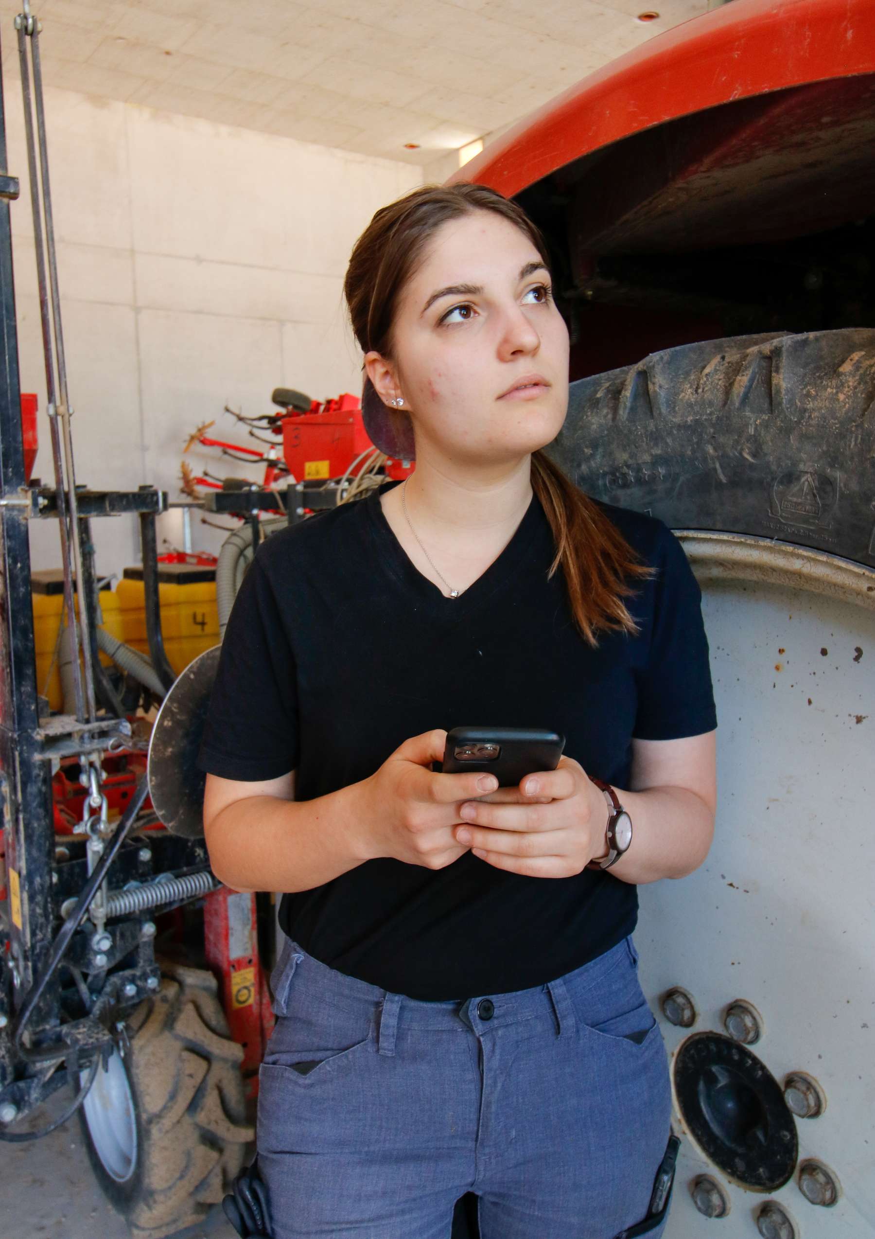 Junge Frau vor Traktor mit Handy.jpg