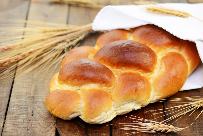 Ein Germstriezel liegt schön geschmückt auf einem Holztisch. Ein Germstriezel liegt schön geschmückt auf einem Holztisch.