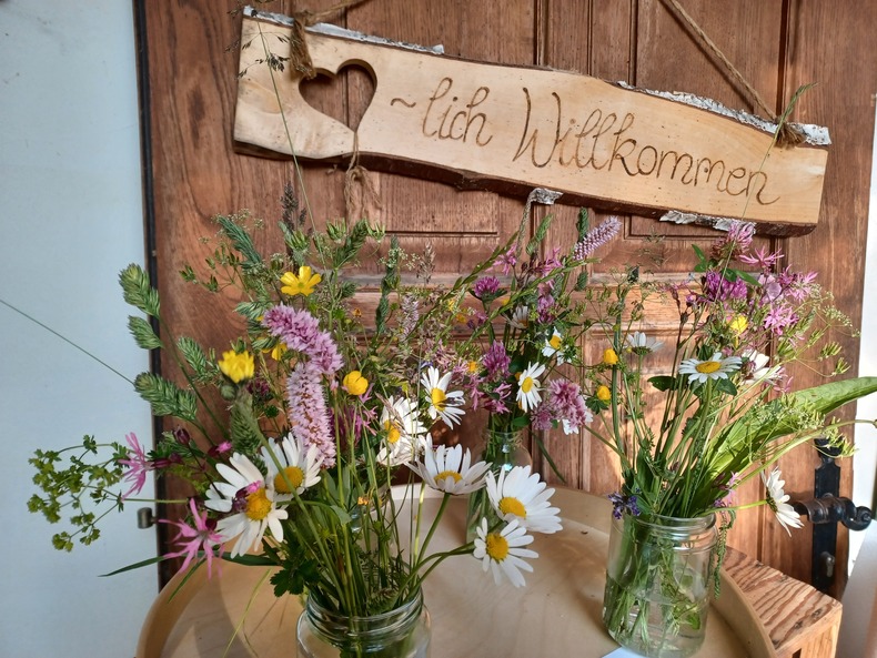 Bunte Wildkräuter-Blumensträuße in Vasen auf einem Tisch. Bunte Wildkräuter-Blumensträuße in Vasen auf einem Tisch.