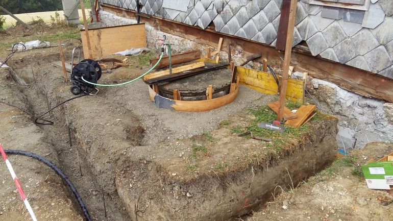 Das Fundament für den Wintergarten wird gerade vorbereitet. Die Baugrube rund um den Brunnen ist auch schon mit Beton verfüllt. Nun kann auch der eigentliche Brunnenkopf fertig gestellt werden. Der Bereich innerhalb der runden Holzschalung wird mit Beton vergossen. © Siegfried Holzeder