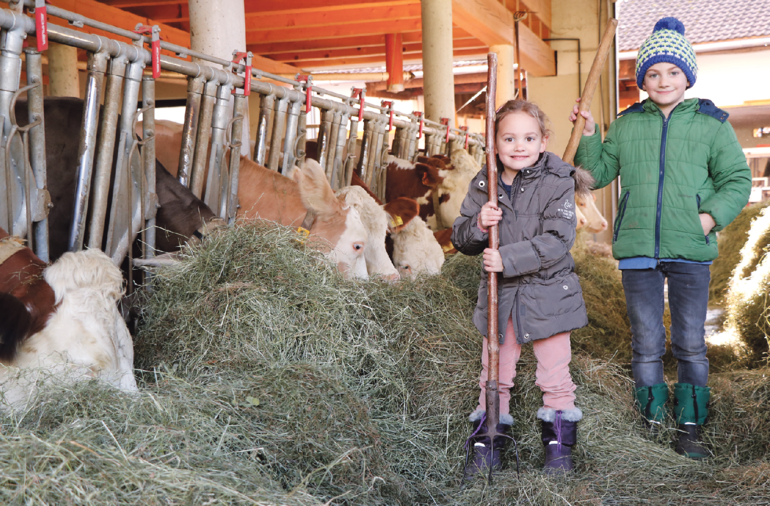 Anna und Georg helfen bereits begeistert im Stall mit. © Kronreif