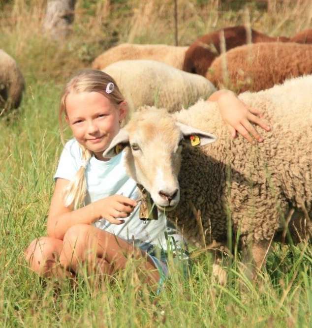 Mädchen kuschelt mit Schaf auf der Weide  Sabine Hofer5.jpg