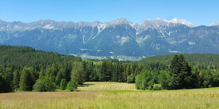 Landschaft in Tirol mit Wiesen, Feldern, Wäldern und Bergen