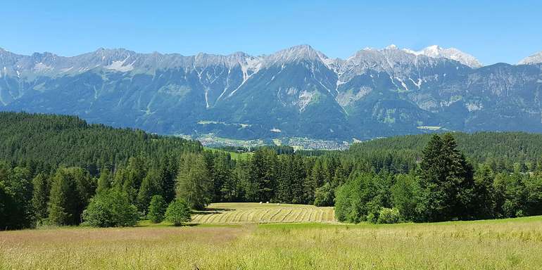 Landschaft in Tirol mit Wiesen, Feldern, Wäldern und Bergen Landschaft in Tirol mit Wiesen, Feldern, Wäldern und Bergen