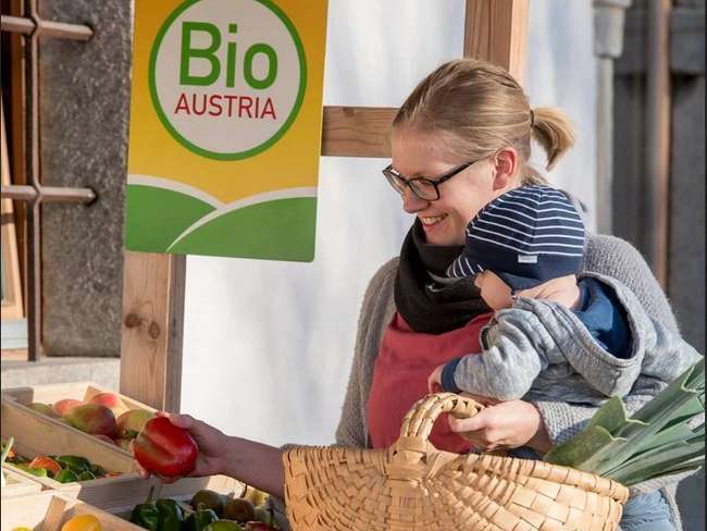 Mutter mit Kleinkind beim Einkaufen von Bio-Lebensmitteln