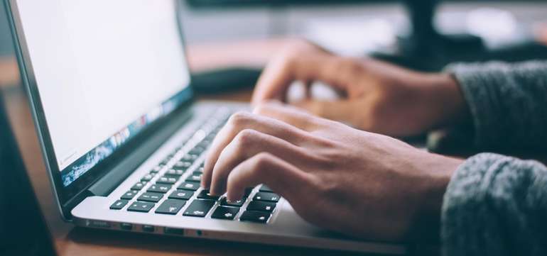 Hände geben am Laptop etwas ein Hände geben am Laptop etwas ein