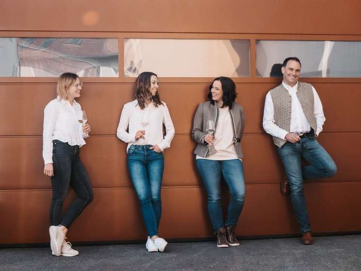 Familie lehnt an Tor ihres Weinkellers © Lorber