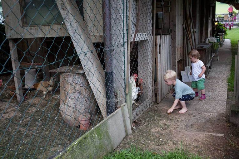 Kinder kniend vor einem Hühnerstall © Lisa Hörterer